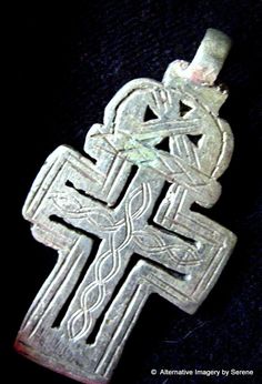 an old silver cross is shown on a black background