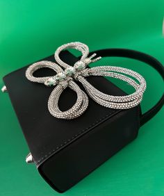 A glamor bag that incorporates elegance and glamour to add subtle sparkle to any outfit. The black satin finish is the perfect summer shade to complement an evening seaside cocktail and its petite size makes it an ideal companion for any occasion. Perfectly fits in your phone and other items. Dimensions: 16cm x 12cm x 7cm Estimated Delivery: 3-5 Days Elegant Silver Clutch With Mobile Phone Bag, Silver Handheld Evening Bag For Mobile Phone, Silver Clutch Evening Bag For Mobile Phone, Luxury Silver Clutch For Cocktail, Luxury Silver Clutch For Cocktail Events, Luxury Silver Cocktail Clutch, Luxury Silver Cocktail Evening Bag, Summer Party Pouch Clutch, Chic Party Clutch For Mobile Phones