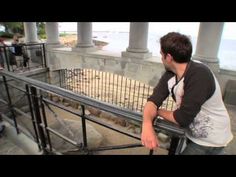 a man leaning on a railing near the ocean