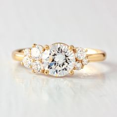 a three stone diamond ring on a white surface