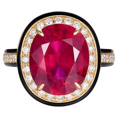 This ring is a bold statement of luxury and color, featuring a stunning 6.58-carat glass-filled ruby as its centerpiece. The ruby, measuring 12x10mm, boasts a rich, deep crimson color that commands attention. The process of glass filling enhances the appearance of the ruby, giving it a remarkable clarity and allowing it to capture light in a way that accentuates its vibrant hue. Surrounding the ruby is a halo of brilliant diamonds totaling 0.46 carats. These diamonds provide a sparkling contrast to the intensity of the ruby, illuminating the ring with their timeless elegance. The ring is crafted in 18 karat yellow gold, which complements the warmth of the ruby and adds a classic sophistication to the piece. The band features a sleek black enamel that frames the ruby and diamonds, creating Crimson Color, Jewelry Ruby, Gold For Sale, Enamel Ring, Leaded Glass, Ruby Diamond, Fine Jewelry Collection, Brilliant Diamond, Cluster Ring