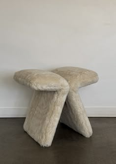 a white bench sitting on top of a floor next to a wall