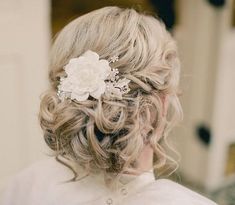 a woman with blonde hair wearing a flower in her hair and a white rose in her hair