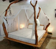 a bed made out of wood and white sheets