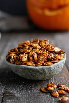 a bowl filled with nuts sitting on top of a wooden table