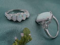 three opalite rings sitting next to each other on a blue cloth with flowers