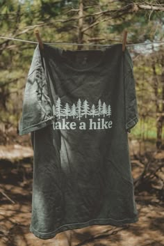 Take A Hike graphic t-shirt. Each t-shirt is pressed house on a comfort colors unisex shirt. T-shirts are made of a soft cotton blend and features a vibrant direct to fabric transfer design that won't fade or crack. COLOR PICTURED: HEMP Shop our wanderlust inspired t-shirt collection. Perfect for those who enjoy hiking, camping, exploring the outdoors and all adventure seeking enthusiasts. keywords: take a hike, outsider hiking shirt, wanderlust t-shirt, adventure t-shirts, graphic tees, unisex Take A Hike Shirt, Custom Print Short Sleeve T-shirt For Outdoor, Cotton Crew Neck T-shirt For Outdoor Activities, Outdoor Relaxed Fit T-shirt With Text Print, Relaxed Fit Short Sleeve T-shirt For Outdoor Activities, Cotton T-shirt With Letter Print For Camping, Outdoor Cotton Shirt With Letter Print, Crew Neck Screen Print T-shirt For Outdoor Activities, Graphic Tee Shirt With Screen Print For Outdoor