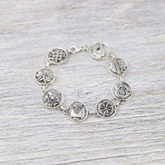 This sterling silver charm bracelet is a great way to accessorize and carry something incredibly meaningful with you throughout the day. Each charm depicts one of the 8 Auspicious Symbols, also known as the "Ashtamangala" in Sanskrit. "Ashta" meaning "eight," and "mangala" meaning "auspicious." Handmade by a fair-trade group of silversmiths in Nepal, this detailed bracelet is finished with a lobster clasp. In Buddhist legend, the 8 Auspicious Symbols represent offerings the gods made to the Budd Handmade Silver Bracelets For Blessing, Antique Silver Sterling Bracelet As Gift, Antique Silver Sterling Bracelet For Gifts, Antique Silver Round Sterling Silver Bracelet For Gift, Antique Silver Round Sterling Silver Bracelet Gift, Gift Round Antique Silver Sterling Bracelet, Spiritual Round Charm Bracelet Gift, Spiritual Good Luck Jewelry Bracelet, Spiritual Silver Metal Bracelets