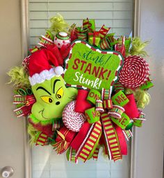 a christmas wreath with the grinch on it is hanging on a front door and says stay stanky, stinky