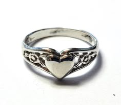 This beautiful sterling silver heart ring is a perfect addition to any jewelry collection. Its filigree design adds a touch of elegance, and the polished finish gives it a luxurious shine. The ring is 1.4 grams and a size 3, making it a great choice for those who appreciate a perfect fit. The ring is made of 925 metal purity and is a band style. This ring is perfect for those who love love-themed jewelry and want to add a unique piece to their collection. It is also sizable, making it a great choice for those who want a custom fit. BB1366 We Combine Shipping   DIAMOND JEWELERS Our feedback score says it all. We only have satisfied customers! BUY or BID WITH CONFIDENCE! Diamond Jewelers is a fine jewelry store on Long Island, NY. We have jewelers on our premises.   Please examine photos and Silver Locket Ring, Heart Locket Ring, Coquette Ring, Silver Vintage Rings, Simple Silver Rings, Silver Rings Women, Rings Dainty, Locket Ring, Antique Jewelry Rings