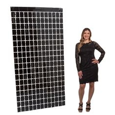 a woman standing next to a black and white tile wall