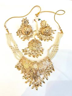 Handcrafted with love to give a real traditional look for this set beautifully studded with Jadau stones and pearls give a royal look. Includes: Necklace, Earrings, and Tikka Formal Bollywood Chandbali Jewelry Sets, Festive Pearl Bridal Earrings With Stone Work, Elegant Bridal Earrings With Stone Work And Pearl, Elegant Pearl Bridal Earrings With Stone Work, Pearl Drop Jewelry Sets For Diwali Gift, Bollywood Style Pearl Bridal Earrings For Festive Occasions, Bollywood Style Bridal Pearl Necklace Gift, Formal Festive Jewelry Sets With Stone Work, Gold Bridal Sets With Stone Work For Celebration