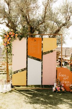 an outdoor ceremony setup with flowers and greenery on the side, including a large sign