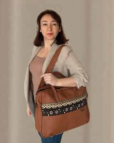 Rug patterned fabric detailed soft real leather brown cognac briefcase laptop bag. There are 8 separate organizer pockets. You can carry all your documents, laptop and daily belongings together. It has separate compartments for laptop, business cards and documents. There are even small pockets specially designed for you to put your fountain pens inside the bag. These laptop briefcase is durable and high quality with lining inside for soft protection. It is a gorgeous gift for birthday, new year and Christmas. It is an unforgettable gift for your co-worker, colleague, manager, girlfriend, sister, wife and anyone else you love. You can personalize this unique design bag by adding a name tag to it. With the laptop briefcase, we send two shoulder straps, one of which is genuine leather and the Cognac Travel Bag With Leather Handles For Business, Business Weekender Bag In Cognac With Luggage Sleeve, Business Weekender Bag With Luggage Sleeve In Cognac, Brown Leather Travel Bag For Business Trips, Brown Business Weekender Bag With Luggage Sleeve, Cognac Shoulder Bag For Business Trips, Luxury Brown Laptop Bag For Travel, Brown Bags With Luggage Sleeve For Business Trips, Brown Tote Travel Bag For Business Trips