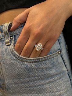 a close up of a person's hand wearing a diamond ring