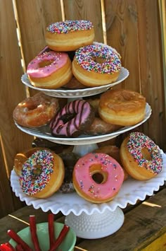 three tiered trays filled with donuts and sprinkles on top of each other