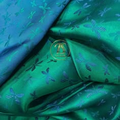 blue and green silk fabric with dragon designs on the bottom, as well as an image of