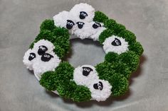 a wreath made out of fake grass with sheep on it and green leaves around the edges