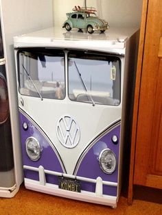 a toy vw bus sitting on top of a refrigerator