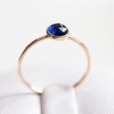 Tiny skinny stackable ring with beautiful deep blue Sapphire stone. It is made with a skinny but sturdy band, which allows you to create beautiful stacking sets! The ring is ideal for everyday wear and it will also look amazing with a festive dress.The ring is 0,8-0,9 mm thick and looks very dainty on the finger. Choose the finish of the stone (smooth cabochon or rose cut) and material for the ring (sterling silver or 9k gold).If you want to change the ring band design or get a custom ring or ri Everyday Minimalist Sapphire Jewelry, Everyday Stackable Sapphire Ring, Everyday Sapphire Ring Jewelry, Sapphire Stackable Rings With Bezel Setting For Promise, Blue Gemstone Dainty Stackable Rings, Everyday Stackable Sapphire Ring Fine Jewelry, Stackable Sapphire Promise Ring, Everyday Fine Jewelry Sapphire Birthstone Ring, Everyday Stackable Sapphire Ring In Fine Jewelry Style