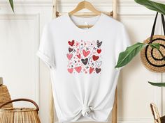 "Wrap your love in a vibrant embrace with our Heartful Harmony T-shirt! 🌈 Overflowing with joy, with the key features a kaleidoscope of brilliantly coloured hearts. Each colour signifies a unique moment, a cherished memory. Let your heart speak louder than words. Gift the magic of love. Wear the warmth, share the joy. Because every heartbeat deserves a celebration!  #HeartfulHarmony #LoveInEveryHue" ✨Sizing✨ Please note that the T-Shirt and its sizing is unisex. Please review the sizes in the l White T-shirt For Valentine's Day Gift, Valentine's Day Graphic Tee With Heart Print, Cute White T-shirt For Valentine's Day, Valentine's Day Heart Print Graphic Tee, Valentine's Day Graphic Tee T-shirt Gift, Cute Heart Print T-shirt For Valentine's Day, Mother's Day Short Sleeve T-shirt With Heart Print, White T-shirt With Heart Print For Mother's Day, White T-shirt With Heart Graphic As Gift