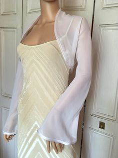 This is a beautiful hand made white chiffon shrug with long FLARED sleeves ideal for weddings or special occasions. It can also be worn with casual wear. It has a silver edging. It can be made in any size from 8 to 24 (UK sizes). It is made in the UK. It is normally sent out to you within 5 days, but I am very happy to make your order a priority if you need it urgently. Just let me know the date needed by. Postage is free in the UK! International postage is £9. I am happy to exchange items or re Dress Covers Shoulder, Dress Cover Up Formal Jacket, Elegant Fitted Summer Shrug, Elegant Stretch Shrug For Spring, Spring Formal Fitted Shrug, Elegant Open Front Summer Shrug, Fitted Shrug For Summer Wedding, Fitted Summer Wedding Shrug, Summer Wedding Fitted Shrug