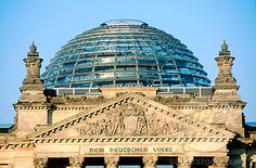 an old building with a domed glass dome on it's roof, in front of a blue sky