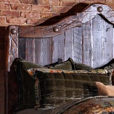 a wooden headboard with two pillows on it and a brick wall in the background