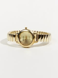 A versatile wristwatch featuring a circular face with a stretchable strap for comfortable wear and timeless style. It effortlessly complements any outfit while ensuring a snug fit on your wrist. Old Fashioned Jewellery, Cute Watches For Women, Women Watch Aesthetic, Little Gold Watch, Classic Gold Round Watch Accessories, Gold Round Watch With Subdials, Small Gold Watch Women, Timeless Gold Jewelry And Watches With Round Shape, Elegant Gold Round Watch Accessories