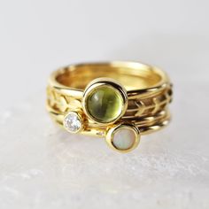 A stunning green peridot stacking ring made from solid 9ct yellow gold. Choose to wear the ring on its own, or mix and match it with other stacking rings from the Nebula collection, or why not add a sparkling Andromeda diamond ring? Peridot is a beautiful juicy green gemstone and the birthstone of August. It is one of only a few stones to come in only one colour, a lovely olive green and is said to bring a wonderful year to whoever wears it. It's warm glowing colour is a reminder of summer and o Gold Stackable Rings With Peridot Birthstone, Stackable Green Diamond Ring In 14k Gold, Yellow Gold Peridot Diamond Ring With Birthstone, Stackable Yellow Gold Peridot Jewelry, Yellow Gold Stackable Opal Ring For Promise, Yellow Gold Peridot Stackable Rings For Anniversary, Yellow Gold Stackable Rings With Peridot, Green Peridot Stackable Rings, Gold Peridot Stackable Rings As Gift