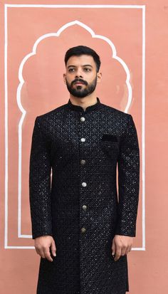 This black Sherwani has a distinctive mandarin collar and a row of hand polished matching buttons down the front. It features long sleeves and has a same colour woven pattern on it. Comes with a churidar pant The Sherwani is made of imported fabric and is available in black as well as other colours like Blue, Red, Green if available on your demand. The package includes this beautiful Sherwani, Churidar pants (which are styled without any specific design) This elegant Sherwani suit is ideal for formal events, parties and evening dinners. Customization options are available for size, design and colour to suit your personal style and taste. We can also give you a turban, jooti, mojari of your matching outfit (additional cost will be apply). For your comfort and best fit we keep 2 Inches Extra Wedding Bandhgala With Cutdana And Brocade, Traditional Ceremonial Sherwani With Zari Weaving, Brocade Sherwani For Eid Reception, Brocade Sherwani With Zari Work For Reception, Traditional Brocade Bandhgala For Reception, Traditional Festive Bandhgala With Zari Weaving, Wedding Bandhgala With Cutdana On Brocade, Diwali Bandhgala With Zari Weaving, Formal Nehru Jacket With Zari Work In Raw Silk