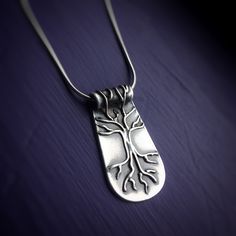 Silver Tree of Life Necklace on purple background. Necklace has roots and branches that go over the bail. Pendants with meaning handmade Vermont. Symbolic Tree Of Life Sterling Silver Jewelry, Symbolic Sterling Silver Tree Of Life Jewelry, Sterling Silver Tree Of Life Nature-inspired Jewelry, Unique Sterling Silver Tree Of Life Necklace, Spiritual Sterling Silver Jewelry With Tree Of Life, Spiritual Tree Of Life Sterling Silver Necklace, Inner Wisdom, Silver Tree, Tree Of Life Necklace