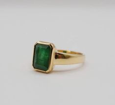 Green 14k Gold Signet Ring With Bezel Setting, Formal Bezel-set Baguette-cut Emerald Ring, Formal Baguette Cut Emerald Ring With Bezel Setting, Classic Bezel Set Ring For May Birthstone, Timeless Bezel-set Emerald Cut Emerald Ring, Classic Green Ring With Bezel Setting, Classic Green Rings With Bezel Setting, Classic Jewelry With Emerald Cut Bezel Setting, Classic Emerald Signet Ring With Bezel Setting