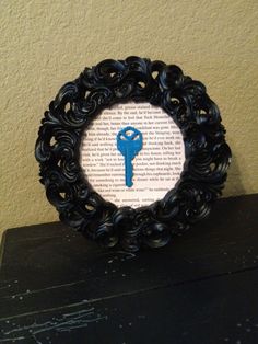 a black frame with a blue key in the middle on top of a wooden table