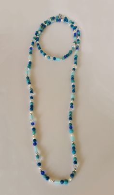 This long classic turquoise blued necklace is perfect for your beach vacation or your summer stay-cation. This long — very long — necklace (with clasp) is great worn alone or wrapped for a shorter, three-strand sophisticated look. Each hand-made necklace from the Classic Collection incorporates Swarovski crystals, freshwater pearls, color-coordinated turquoise beads and other blue stones and Silver accents in its design. You'll feel soft and feminine when you wear this necklace, whether that is Blue Single Strand Beaded Necklace For Summer, Summer Blue Gemstone Beads Jewelry, Lariat Beaded Necklace With Gemstone Beads For Beach, Long Turquoise Necklace For The Beach, Turquoise Jewelry With Faceted Beads For Summer, Long Beach Jewelry Necklace With 108 Beads, Turquoise Long Necklace For The Beach, Beach Jewelry With 108 Beads Long Necklace, Handmade Blue Turquoise Necklace For Summer