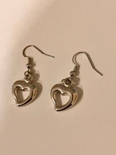 Adorable silver dangly heart earrings. cute y2k themed aesthetic earrings. Trendy Metal Heart Earrings For Pierced Ears, Trendy Metal Heart Pierced Earrings, Trendy Metal Heart Drop Earrings, Trendy Nickel-free Metal Heart Earrings, Trendy Silver Double Heart Earrings, Trendy Dangle Heart Earrings, Trendy Silver Heart Charm Earrings, Trendy Silver Dangle Heart Earrings, Trendy Pierced Heart Dangle Earrings