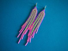 Stripes of neon purple contrast against neon green and blend into hot pink at the tips of the fringes of these very lightweight fringe earrings. They have seven strands of beads measuring 4 1/2 inches long as suspended from sterling silver lever backs with a width of 5/8 inch. Purple Contrast, Neon Stripes, Bead Projects, Seed Bead Patterns, Neon Purple, Pink Neon, Beaded Fringe, Bead Patterns, Fringe Earrings