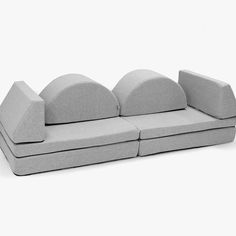 a gray couch with three pillows on it's back and one arm facing the camera