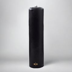 a tall black candle sitting on top of a table