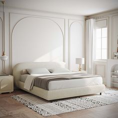 a white bed sitting in a bedroom on top of a hard wood floor