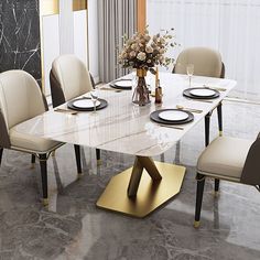 a marble dining table with beige chairs and plates on the plate stand in front of it