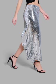 This mid-rise Silver Sequin Diagonal Maxi Skirt has an asymmetrical cut at the bottom. This skirt is noted for its uniqueness in design and its versatility. This product is styled with the Black Satin Arc-Cut Top. Asymmetrical Cut, Cut Top, Cape Coat, Silver Sequin, In Design, Skirt Top, Black Satin, Coat Dress, Skirt Pants