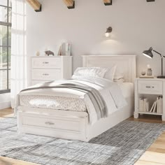 a white bedroom with a bed, dressers and drawers on the floor in front of a window