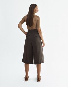 High-waisted below knee-length shorts IPANTS.A wide waistband along with front pleats highlight the waist and make it visually thinner. Bermuda shorts are made from heavy wool in soft brown color and have an extra lining to be more pleasant to the body. Shorts have comfortable side pockets and faux pockets on the back. Belt loops, zip, and hook-and-eye closures on the middle.Composition: 35% wool, 40% viscose, 20% polyester, 2% elastaneLining: 100% viscoseCare: We recommend a professional dry cl Brown Shorts For Workwear, Brown Workwear Shorts, Knee-length Workwear Culottes With Pockets, Knee-length Culottes With Pockets For Work, Elegant Knee-length Bermuda Shorts With Pockets, Elegant Knee-length Shorts For Workwear, Elegant Knee-length Shorts For Work, Workwear Culottes With Pockets In Short Length, Workwear Short Culottes With Pockets