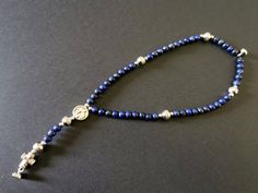 "Handmade Christian jewelry lapis rosary bracelet with cross bead | unisex faith gift with custom devotional medal | AndavyGifts --------------------------------------------- YOUR ROSARY READY FOR PRAYER WHEREVER YOU ARE! This rosary bracelet is actually a full 5-decade stretch rosary, with a strong magnetic clasp, handmade with the following materials: - 4mm \"Hail Mary\" lapis lazuli beads - 6mm \"Our Father\" stainless steel beads - 2mm spacer beads - galvanized alloy sideway cross bead - cus Bracelet With Cross, Lapis Lazuli Beads, Faith Gifts, Rosary Bracelet, Hail Mary, Rosary Beads, Catholic Gifts, Christian Jewelry, Magnetic Clasp