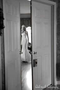 a woman in a wedding dress looking at herself in the mirror