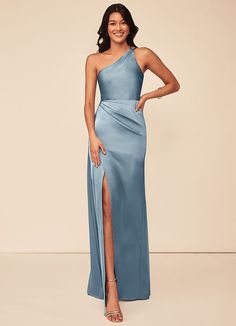 a woman in a blue one - shoulder dress with a slit on the side and her legs crossed