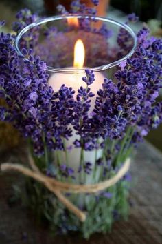 a candle that is sitting in a glass vase with lavenders on it and the words crea bonitos portavelasa o comparitar