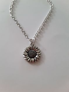 sunflower charm necklace, antique silver charm, dainty, fun gift Silver Charm Necklace In Alloy, Everyday Silver Necklace With Vintage Charm, Dainty Silver Sunflower Jewelry, Nickel-free Silver Flower Charm Necklace, Dainty Metal Necklace With Flower Charm, Handmade Silver Alloy Charm Necklaces, Handmade Silver Charm Necklace In Alloy, Silver Alloy Necklace With Flower Pendant, Silver Charm Necklace With Flower Charm