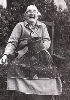 an old woman sitting in a chair laughing